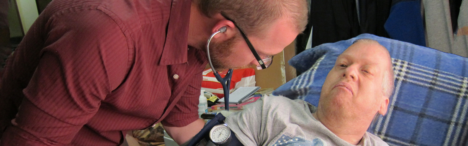 Healthcare provider taking a patient's blood pressure.