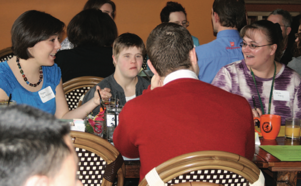 A small group at a restaurant table participate in intentional dialogue