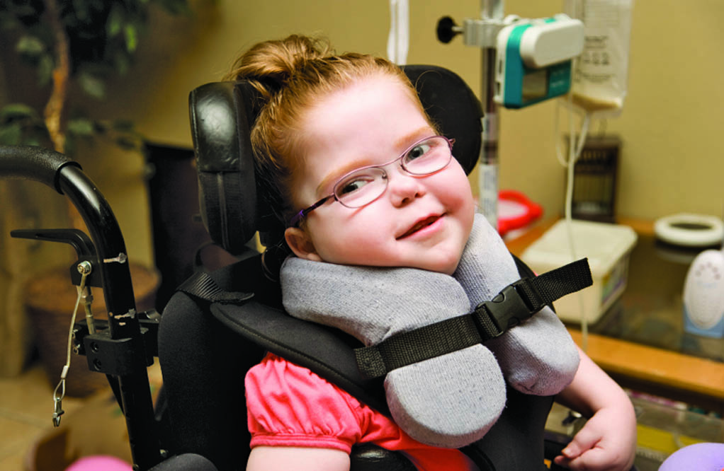 Smiling girl in a wheelchair.