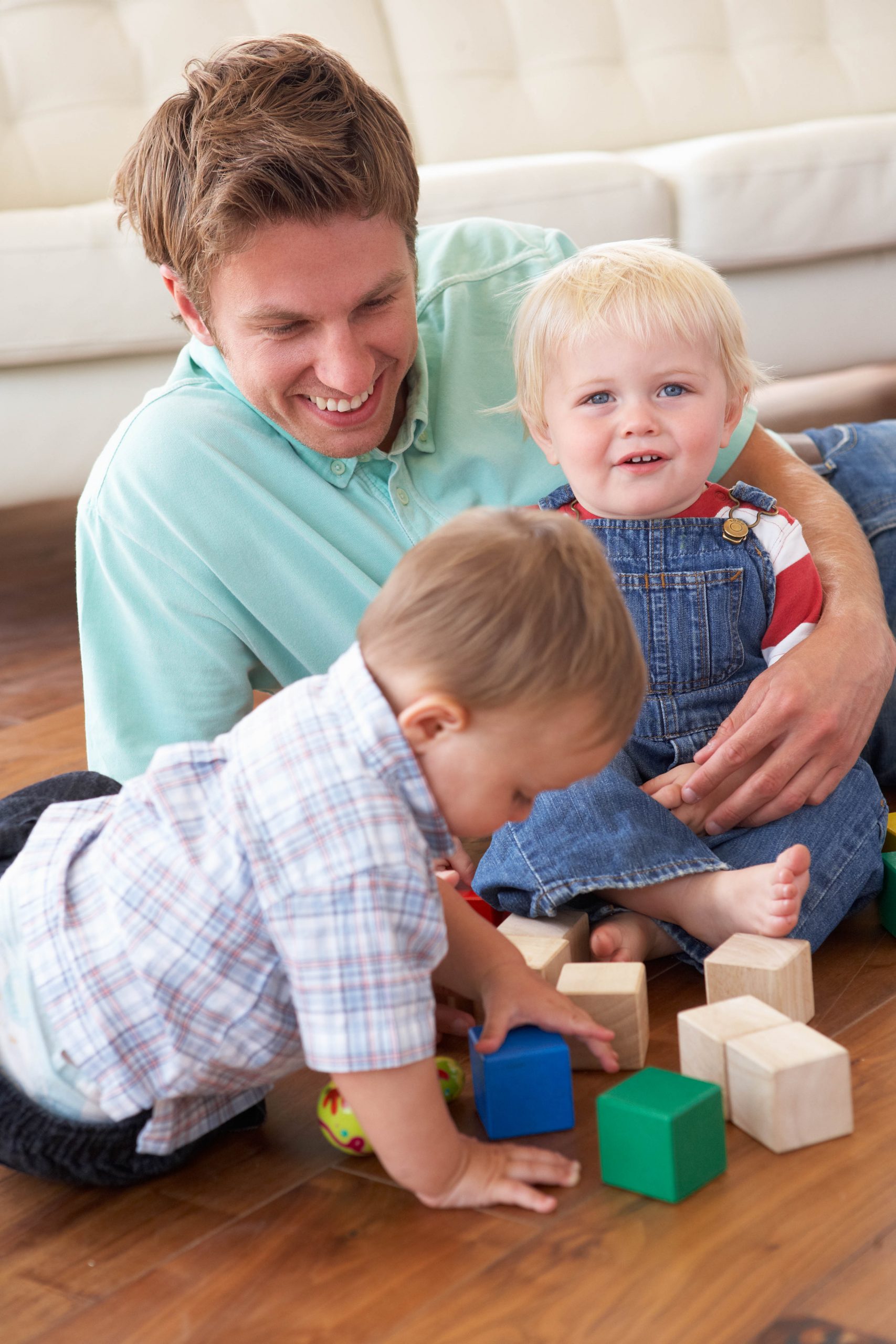 Father playing with colored blocks with his two young sons.