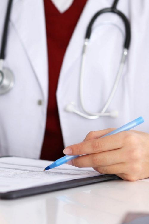 medical person holding a pen on form