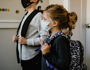 young children masked backpacks