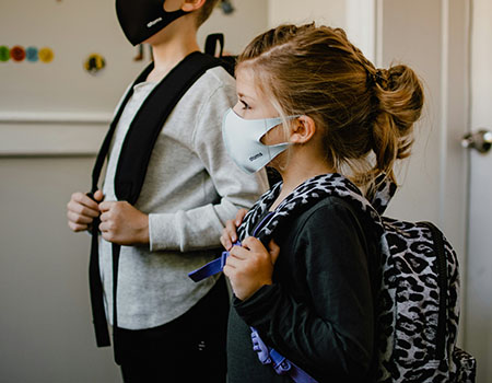 young children masked backpacks