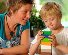 child with teacher, playing with blocks