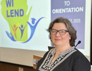 LEND Director Gail Chodron in front of slide of WI LEND program welcome